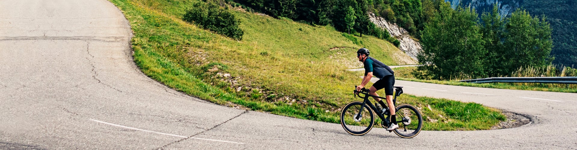 Cyclist riding up green hill