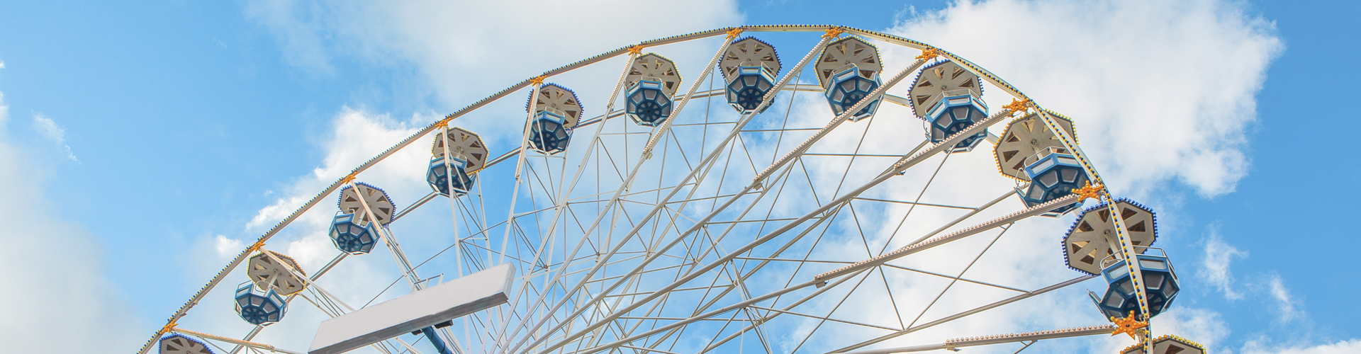 Colorful ferris wheel in an amusement park against blue sky